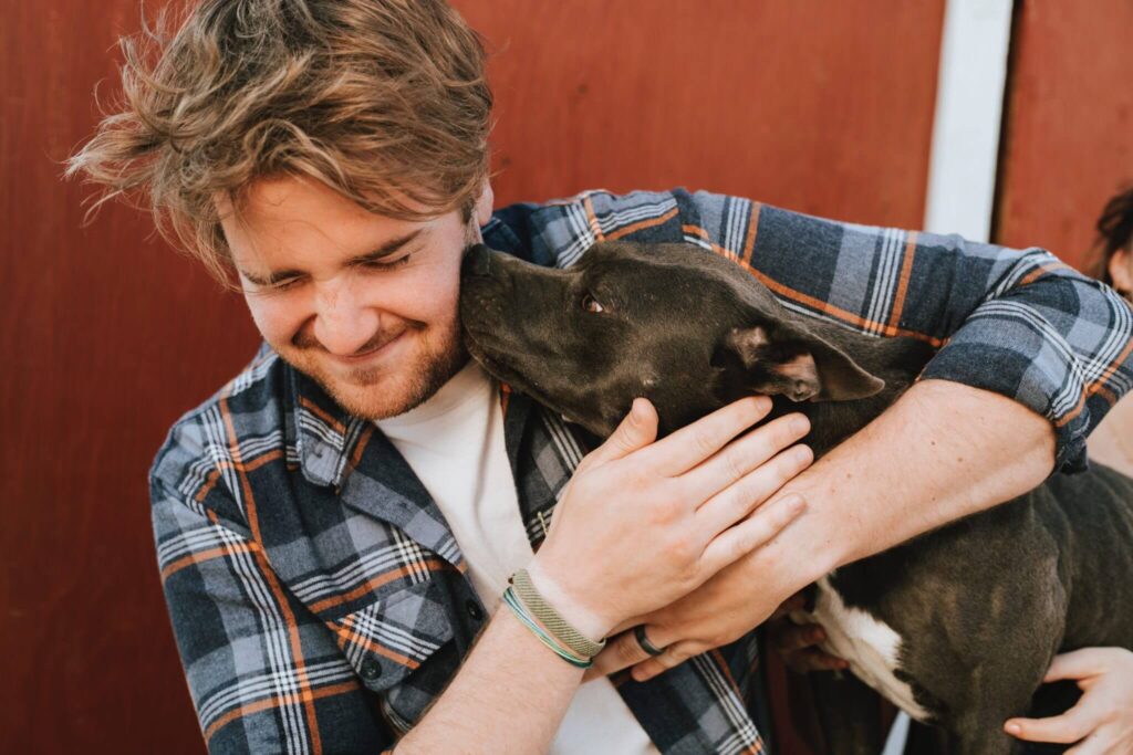 Man cuddles with his dog.
