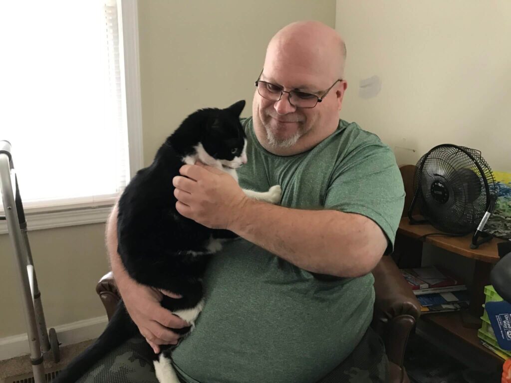 A military veteran holds a cat he adopted through the MHS for Military adoption program.
