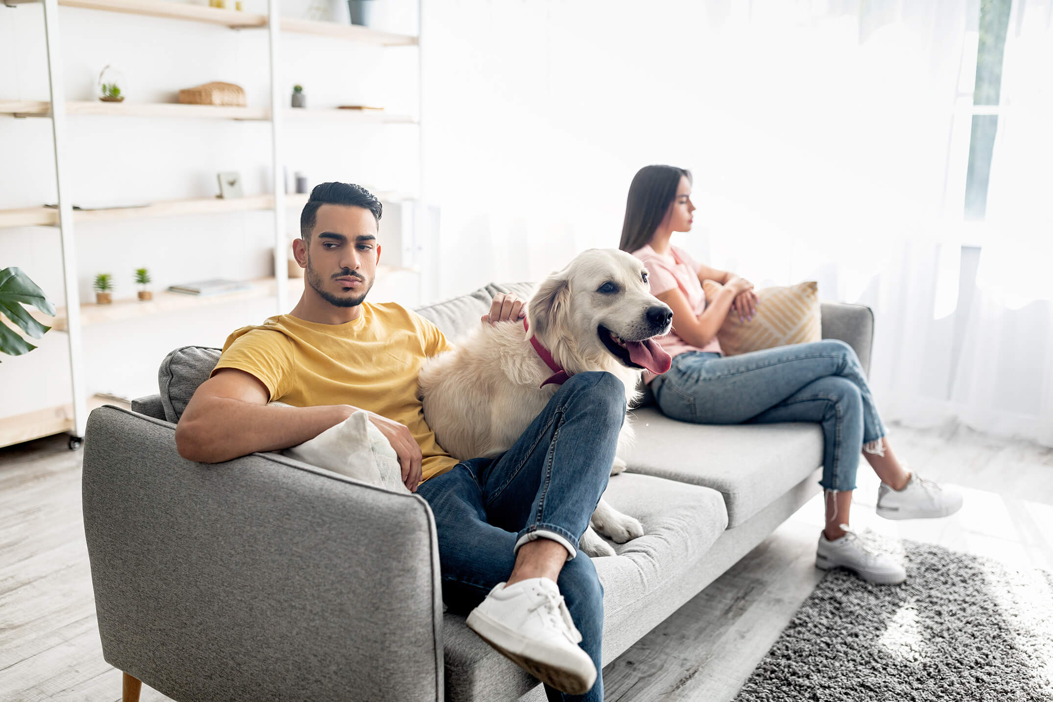Couple fighting while dog sits on couch