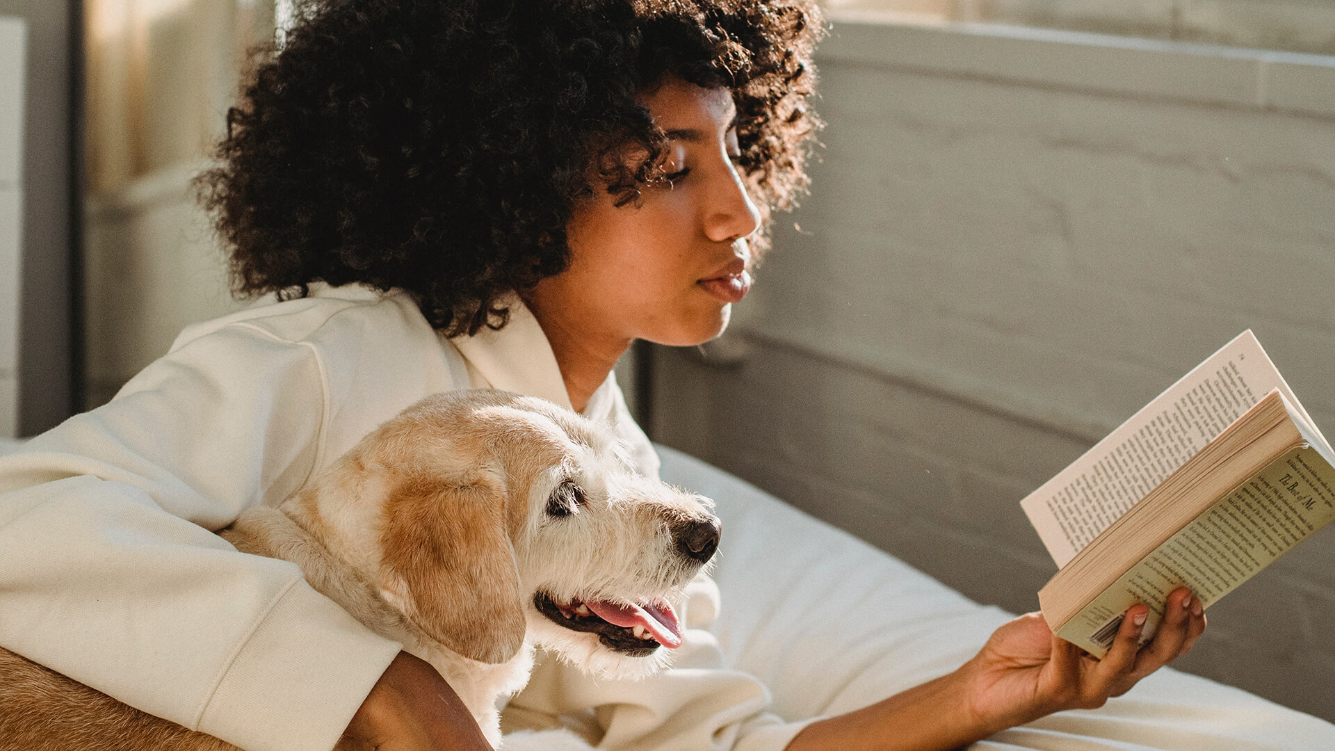 Woman reads book with her dog