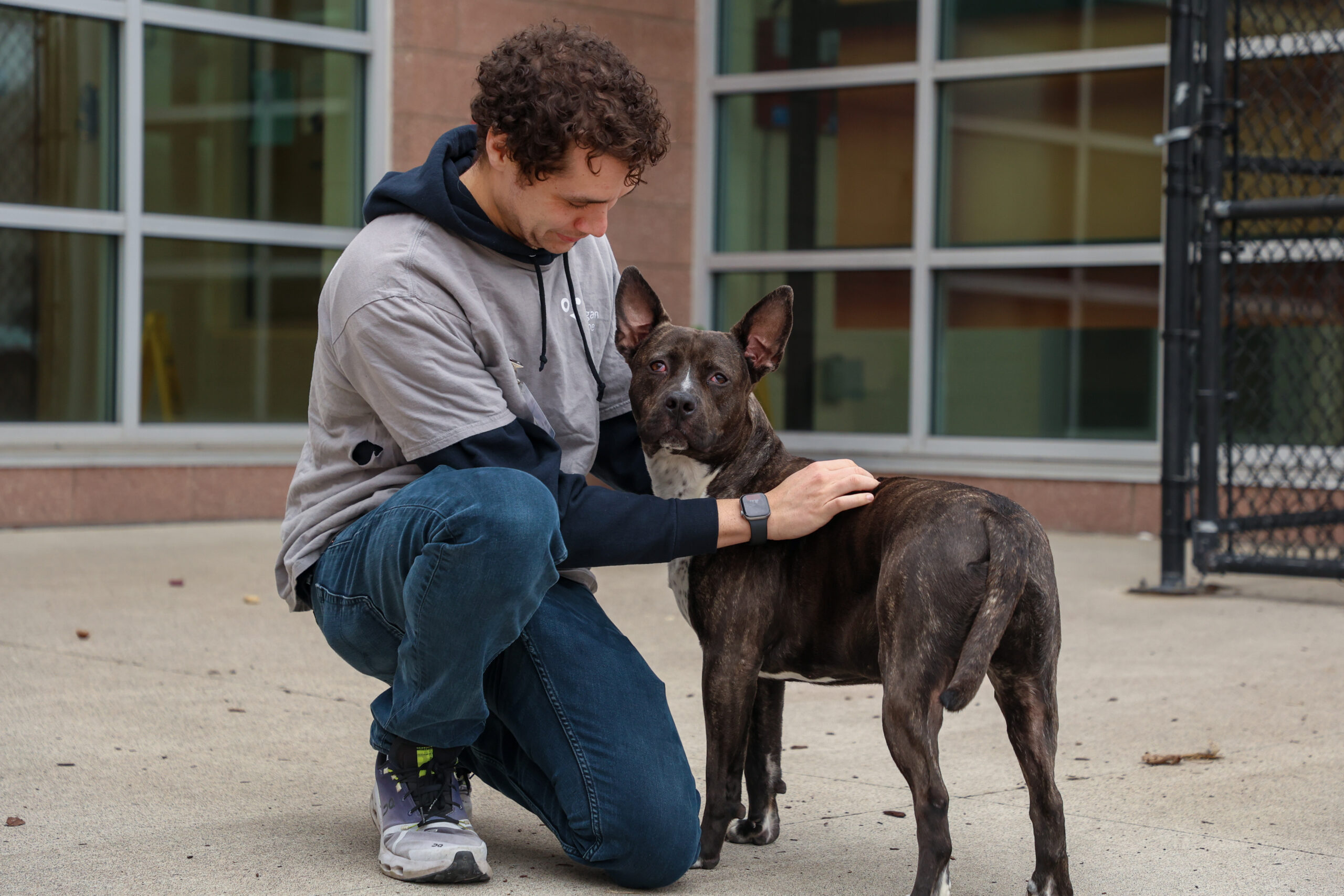 Person kneeling down next to dog