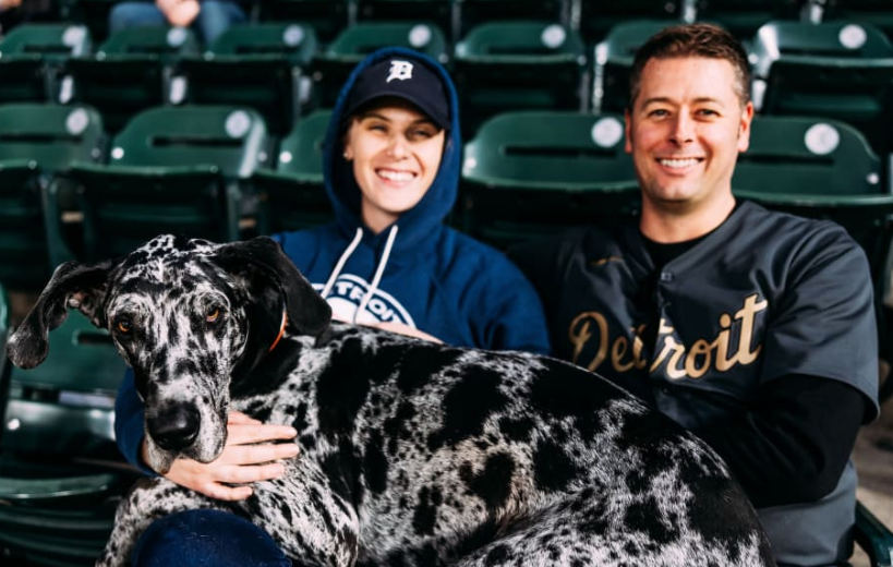A couple at the ballgame with their great dane