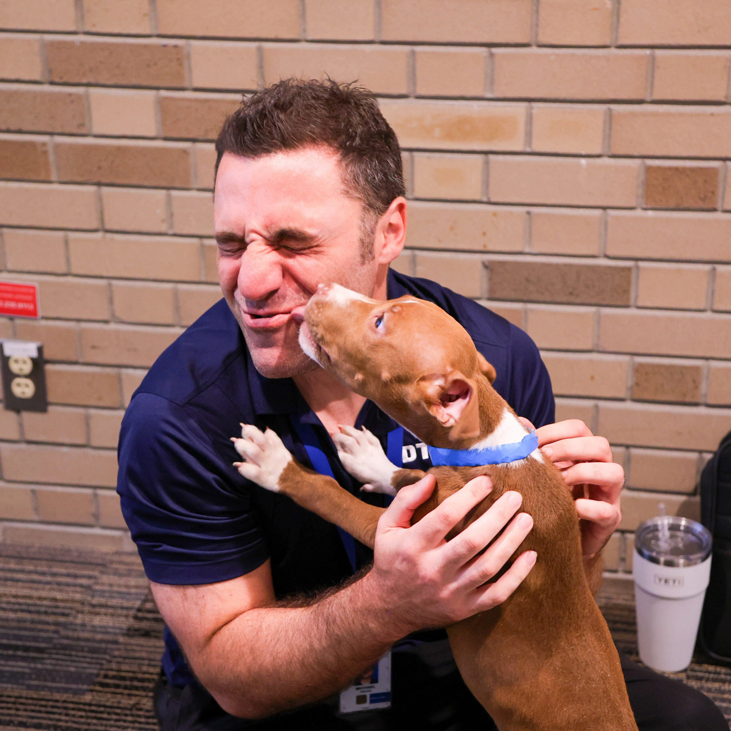 Dog giving man kisses.
